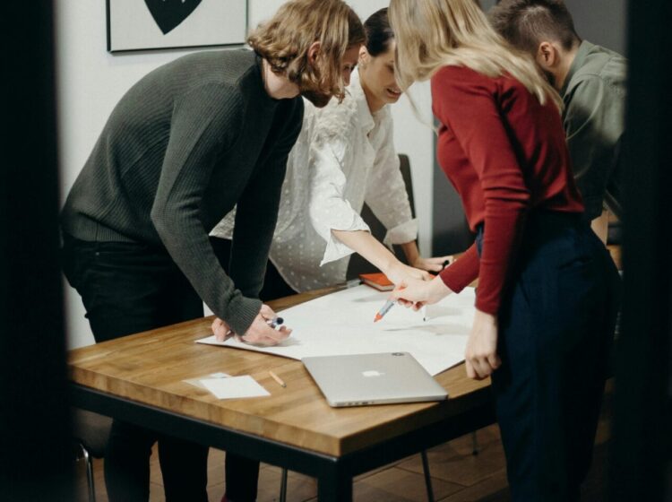 Group of diverse professionals brainstorming ideas in a stylish modern office space.